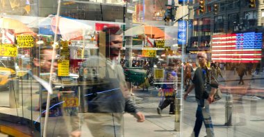 People are reflected in a shop window at Times Square in the Manhattan borough of New York, U.S., April 24, 2026. (AFP Photo)