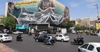 Vehicles drive past a giant billboard reading "The Strait of Hormuz remains closed" at the Revolution Square, Tehran, Iran, April 28, 2026. (AFP Photo)