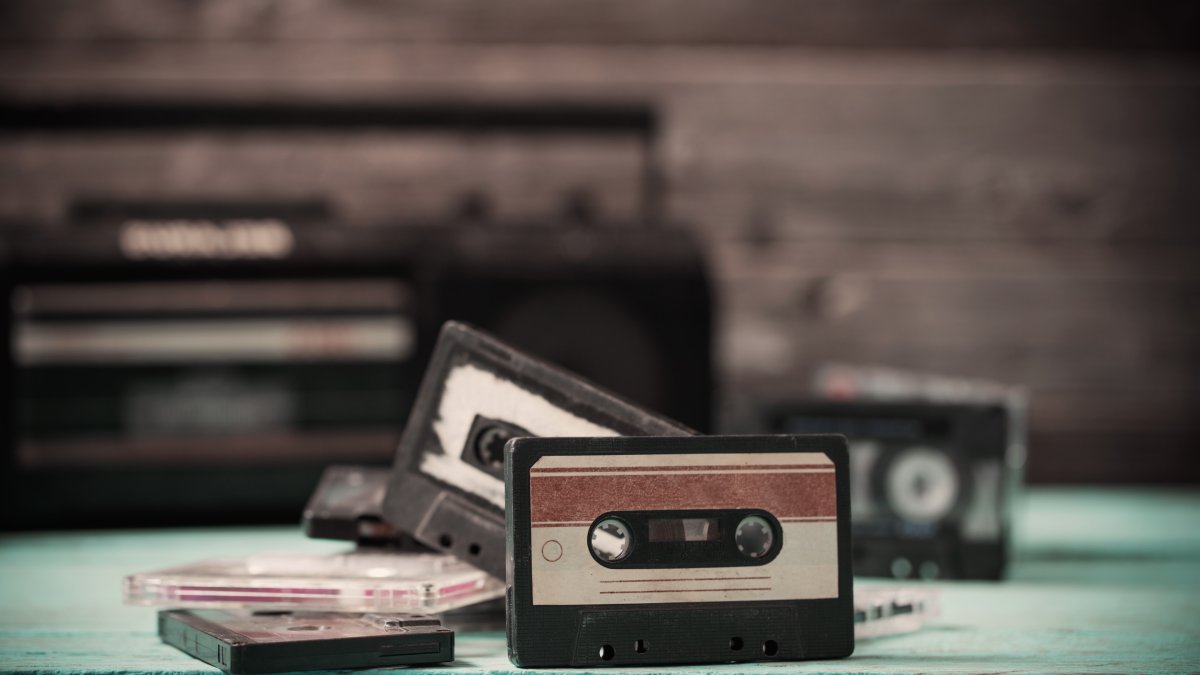 An old cassette tape and player on a wooden background. (Shutterstock Photo)