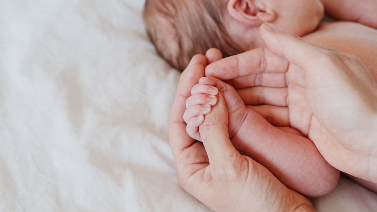 Close-up little hand of child baby holding hand of mother. (Shutterstock Photo)