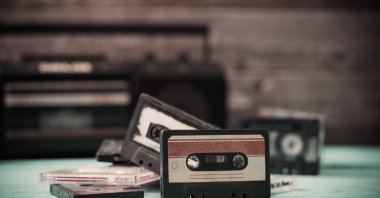 An old cassette tape and player on a wooden background. (Shutterstock Photo)