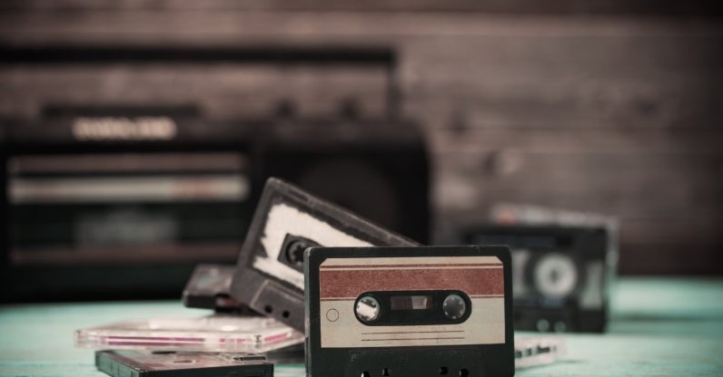 An old cassette tape and player on a wooden background. (Shutterstock Photo)
