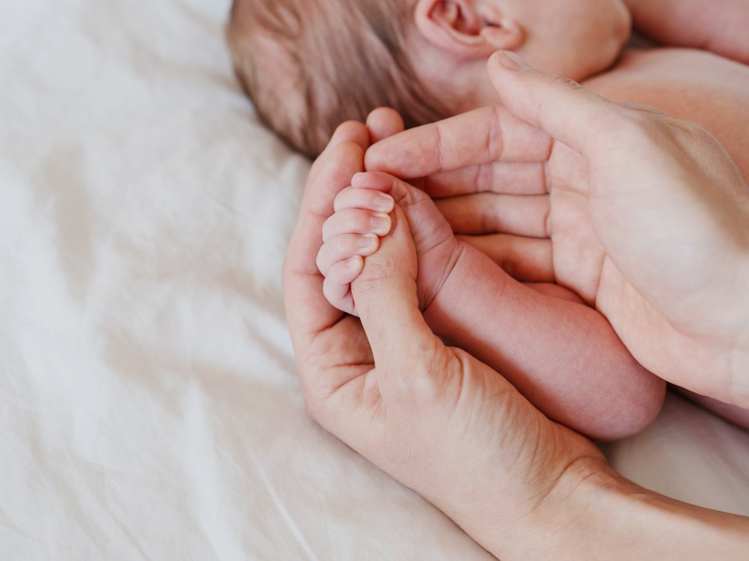 Close-up little hand of child baby holding hand of mother. (Shutterstock Photo)