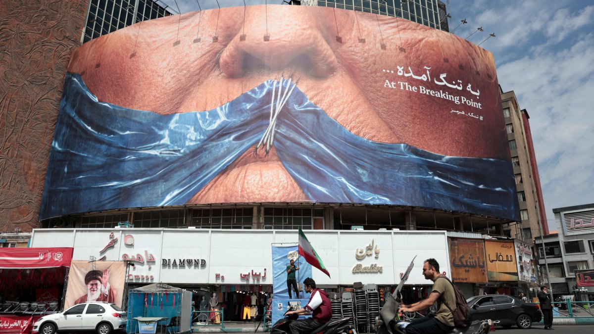 Motorists ride past an anti-U.S. billboard referring to President Donald Trump and the Strait of Hormuz, installed on a building at the Valiasr Square in Tehran, Iran, May 2, 2026. (AFP Photo)