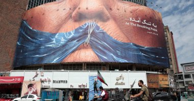 Motorists ride past an anti-U.S. billboard referring to President Donald Trump and the Strait of Hormuz, installed on a building at the Valiasr Square in Tehran, Iran, May 2, 2026. (AFP Photo)