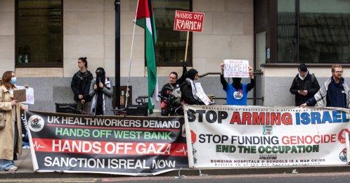 A group of pro-Palestinian protesters hold banners and placards outside the Westminster Magistrates' Court on London, UK, March 27, 2026. (Getty Images Photo)