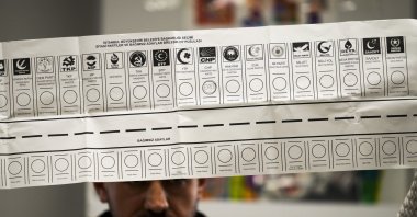 An election representative holds a ballot with the names of parties at a polling station, Istanbul, Türkiye, March 31, 2024. (AP Photo)
