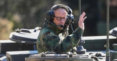 German Chancellor Friedrich Merz waves as he is driven in a tank at the German army barracks in Munster, northern Germany, April 30, 2026. (AFP Photo)