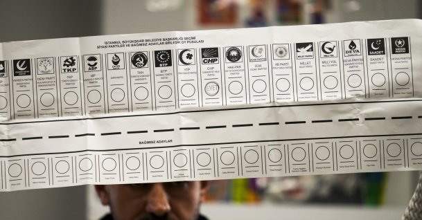 An election representative holds a ballot with the names of parties at a polling station, Istanbul, Türkiye, March 31, 2024. (AP Photo)
