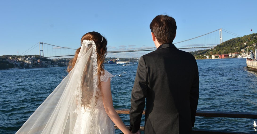 A bride and groom watching the Bosporus Bridge by the sea, Istanbul, Türkiye, Oct. 14, 2023. (Shutterstcok Photo)