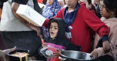 Displaced Palestinian children receive food from a charity kitchen at the Nuseirat refugee camp in the central Gaza Strip, April 13, 2026. (AFP Photo)