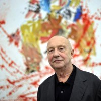 German artist Georg Baselitz poses in front of his painting "Modern Painter (remix)" during an exhibition of his work in Baden, the southern German city of Baden, Germany, Nov. 19, 2009. (Getty Images Photo)