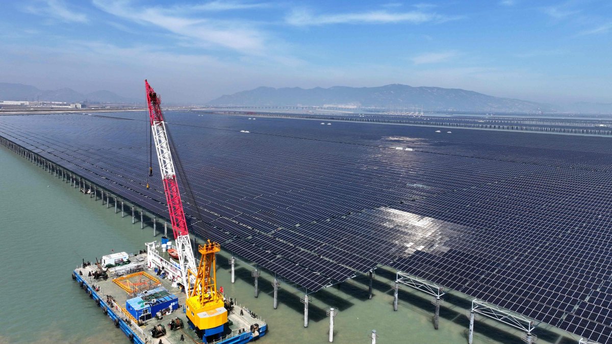 Workers install solar panels with a crane at the CNNC Tianwan tidal flat photovoltaic power plant, Lianyungang, eastern Jiangsu province, China, April 19, 2026. (AFP Photo)
