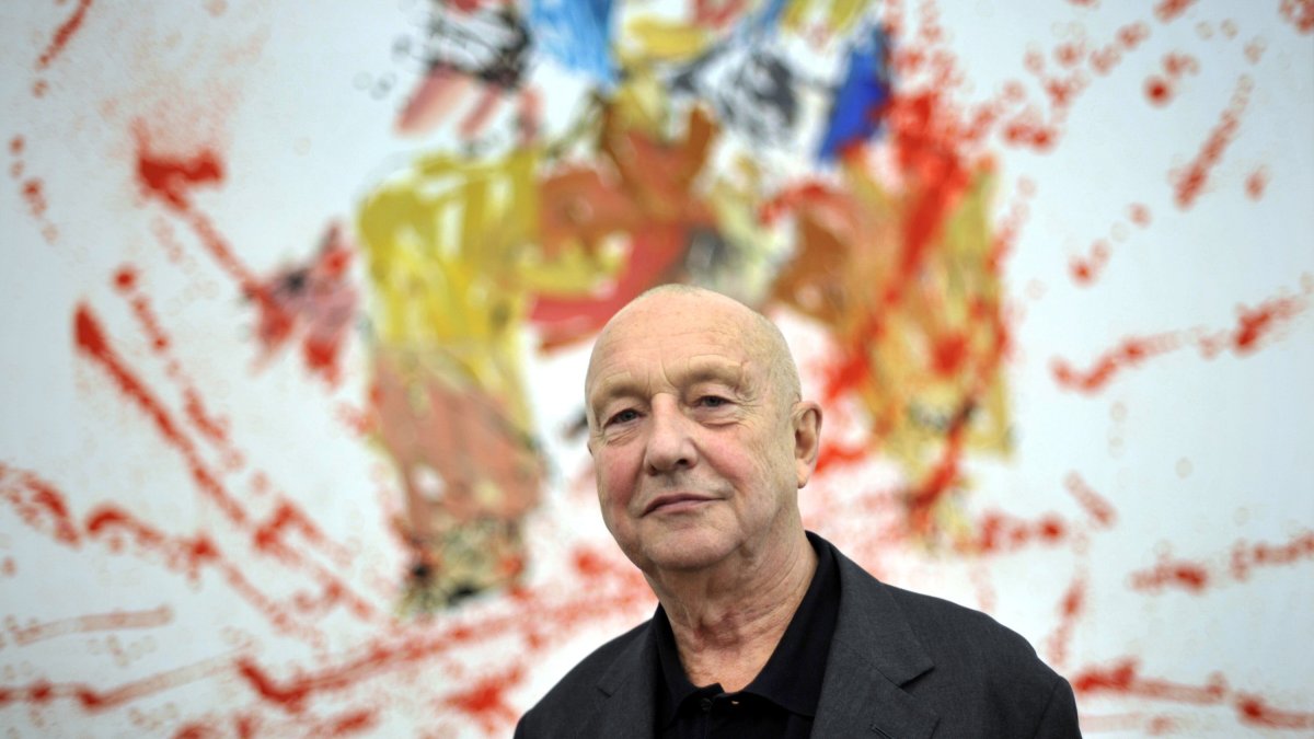 German artist Georg Baselitz poses in front of his painting "Modern Painter (remix)" during an exhibition of his work in Baden, the southern German city of Baden, Germany, Nov. 19, 2009. (Getty Images Photo)