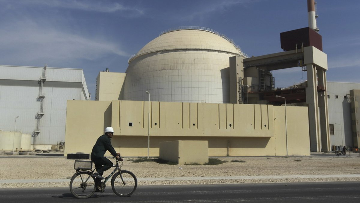 A worker rides a bike in front of the reactor building of the Bushehr nuclear power plant, just outside the southern city of Bushehr, Iran, Oct. 26, 2010. (AP Photo)