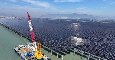 Workers install solar panels with a crane at the CNNC Tianwan tidal flat photovoltaic power plant, Lianyungang, eastern Jiangsu province, China, April 19, 2026. (AFP Photo)