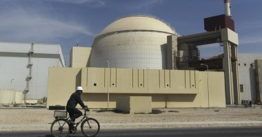 A worker rides a bike in front of the reactor building of the Bushehr nuclear power plant, just outside the southern city of Bushehr, Iran, Oct. 26, 2010. (AP Photo)