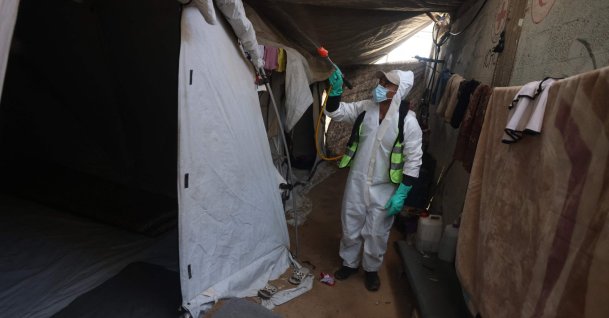 A displaced Palestinian working at the Khan Yunis municipality disinfects the pathways and tents at a displacement camp to eliminate insects and critters, following a significant infestation of pests among residents, in Khan Yunis, in the southern Gaza Strip, Palestine, April 22, 2026. (AFP Photo)