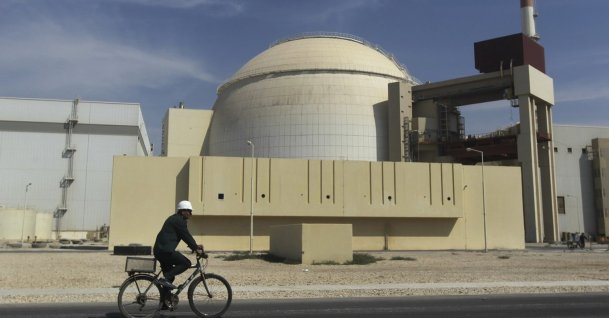A worker rides a bike in front of the reactor building of the Bushehr nuclear power plant, just outside the southern city of Bushehr, Iran, Oct. 26, 2010. (AP Photo)
