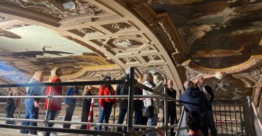 People look at a restored painting of Gustav Klimt during a guided tour of the restoration of the ceiling paintings at the Burgtheater, Vienna, Austria, April 20, 2026. (AP Photo)
