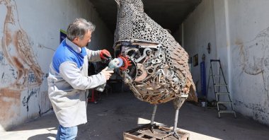 Painter and sculptor Nurettin Çakmak with his pigeon sculpture, Mardin, Türkiye, May 5, 2026. (AA Photo)