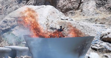 A pit filled with weapons is set on fire by members of the terrorist group PKK during a ceremony in Sulaimaniyah, Iraq, July 11, 2025. (AFP File Photo)