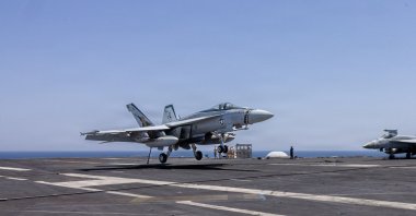 This U.S. Navy handout photo released on May 6, 2026 by U.S. Central Command Public Affairs, shows an F/A-18E Super Hornet landing aboard Nimitz-class aircraft carrier USS George H.W. Bush (CVN 77) at sea on April 27, 2026. (AFP via CENTCOM)