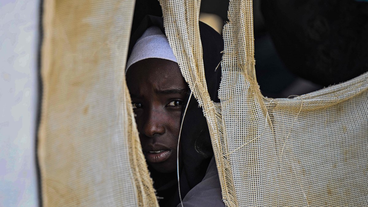 A displaced Sudanese student looks out from a tent at an elementary school, south of Port Sudan, April 26, 2026. (AFP Photo)