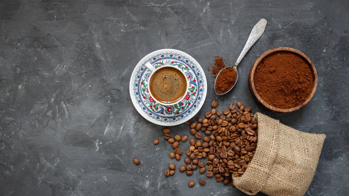 A Turkish coffee concept featuring a cup of coffee with coffee beans arranged on a wooden background. (Shutterstock Photo)