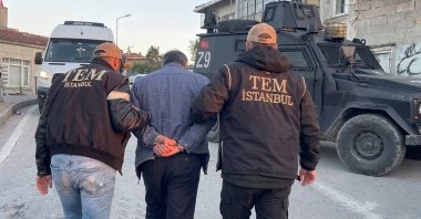 Two police officers escort a captured suspect in this AI-enhanced photo, Istanbul, Türkiye, May 7, 2026. (DHA Photo)