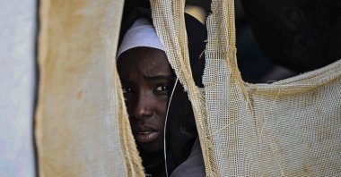 A displaced Sudanese student looks out from a tent at an elementary school, south of Port Sudan, April 26, 2026. (AFP Photo)