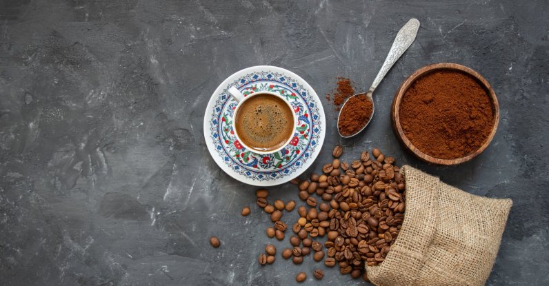 A Turkish coffee concept featuring a cup of coffee with coffee beans arranged on a wooden background. (Shutterstock Photo)