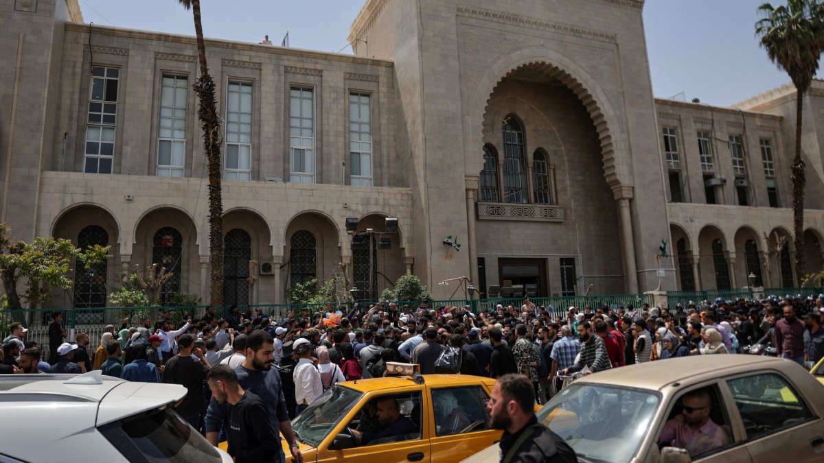 People gather outside the Palace of Justice, on the day of a trial session of Atef Najib, a brigadier general and former head of the Political Security Department in Daraa during Syria's ousted dictator Bashar Assad's rule, in Damascus, Syria, April 26, 2026. (Reuters Photo)