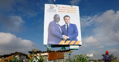 A pedestrian walks near a billboard featuring Kenyan President William Ruto and French President Emmanuel Macron ahead of the "Africa Forward" Summit, Nairobi, Kenya, May 7, 2026. (Reuters Photo)