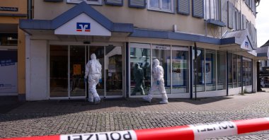 Members of the forensics team enter the savings bank branch amid response to a hostage-taking situation in the western town of Sinzig, near Bonn, in the state of Rhineland-Palatinate, Germany, May 8, 2026. (Reuters Photo)