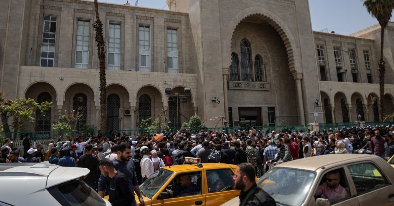 People gather outside the Palace of Justice, on the day of a trial session of Atef Najib, a brigadier general and former head of the Political Security Department in Daraa during Syria's ousted dictator Bashar Assad's rule, in Damascus, Syria, April 26, 2026. (Reuters Photo)