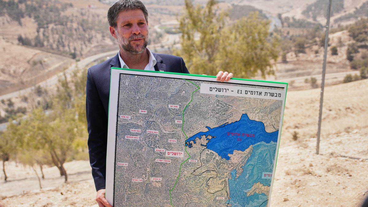 Israeli Finance Minister Bezalel Smotrich holds a map that shows the E1 settlement project during a press conference near the settlement of Maale Adumim, Israeli-occupied West Bank, Palestine, Aug. 14, 2025. (AP Photo)
