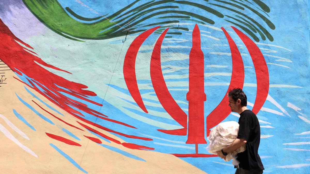 An Iranian man walks past an anti-U.S. and anti-Israel mural painted on a wall in Tehran, Iran, May 10, 2026. (AFP Photo)