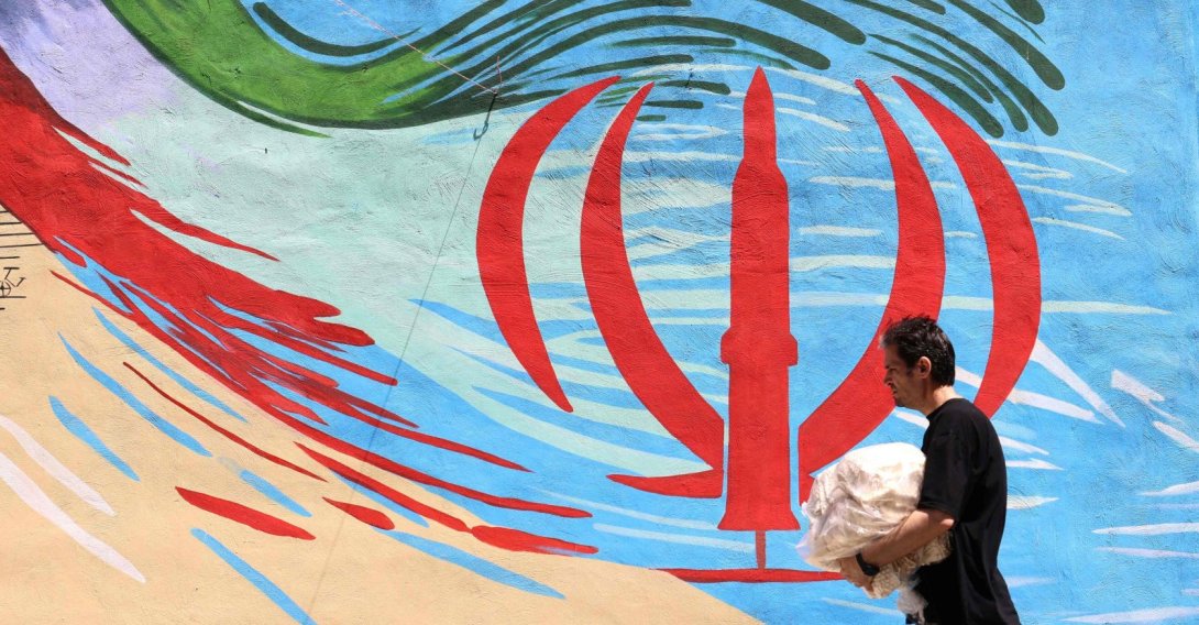 An Iranian man walks past an anti-U.S. and anti-Israel mural painted on a wall in Tehran, Iran, May 10, 2026. (AFP Photo)