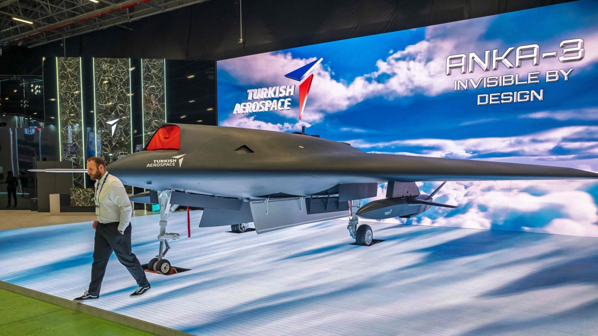 A man walks past an Anka-3, Türkiye's first flying-wing, deep-strike stealth unmanned fighter jet, manufactured by Turkish Aerospace Industries (TAI) during the opening day of SAHA 2026, an international defense and aerospace exhibition, Istanbul, Türkiye, May 5, 2026. (AFP Photo)