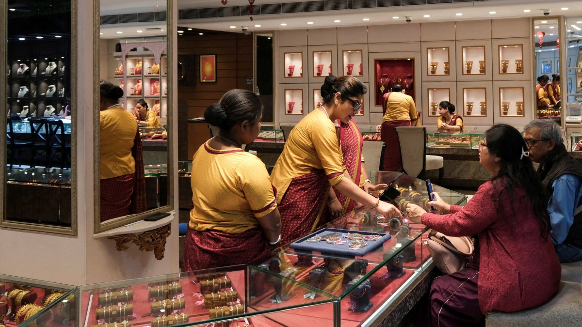 Salespeople show gold ornaments and jewelry to customers for purchase inside a showroom in Kolkata, India, Jan. 28, 2026. (Reuters Photo)