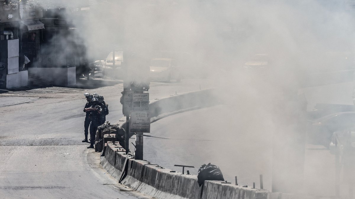 Smoke fills a street as Israeli security forces patrol during a military raid in the Qalandia refugee camp, south of Ramallah in the Israeli-occupied West Bank, May 11, 2026. (AFP Photo)