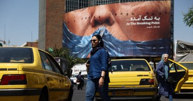 A woman walks past an anti-U.S. billboard depicting U.S. President Donald Trump and the Strait of Hormuz, Tehran, Iran, May 11, 2026. (Reuters Photo)