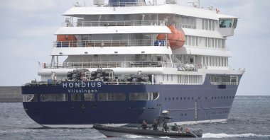 A Spain's Guardia Civil boat sails next to Dutch flagged hantavirus-stricken cruise ship MV Hondius in the port of Granadilla de Abona on the island of Tenerife in Spain's Canary Islands, May 11, 2026. (AFP Photo)
