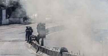 Smoke fills a street as Israeli security forces patrol during a military raid in the Qalandia refugee camp, south of Ramallah in the Israeli-occupied West Bank, May 11, 2026. (AFP Photo)
