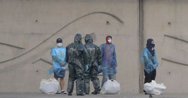 Spain's Guardia Civil officers talk with persons with protective suits disembarking from the hantavirus-stricken cruise ship MV Hondius docked in the port of Granadilla de Abona on the island of Tenerife in Spain's Canary Islands, May 11, 2026. (AFP Photo)