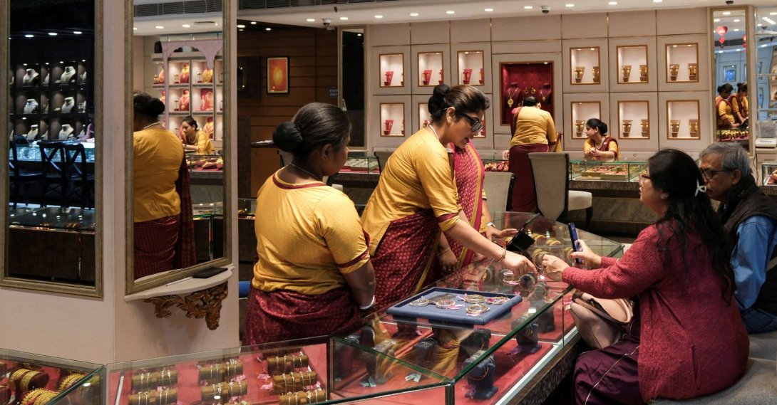 Salespeople show gold ornaments and jewelry to customers for purchase inside a showroom in Kolkata, India, Jan. 28, 2026. (Reuters Photo)