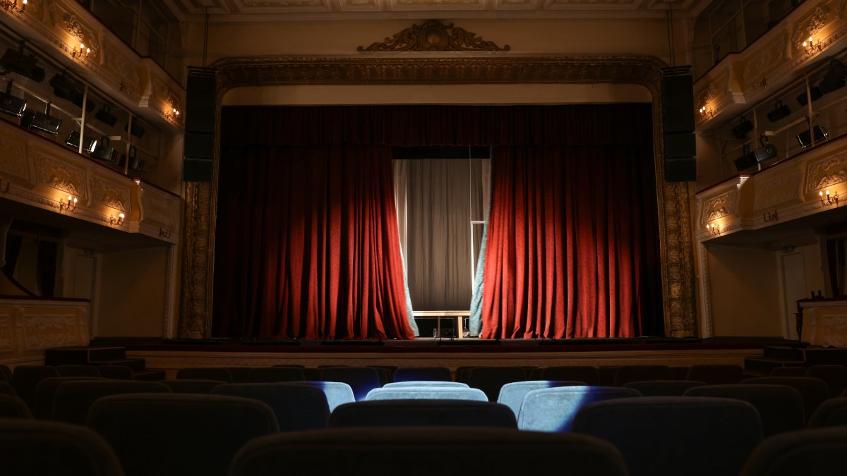 A view of a theater interior with a stage and rows of seats. (Shutterstock Photo)