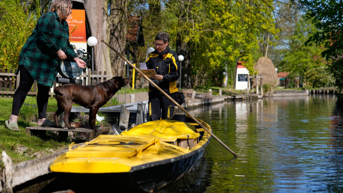 Mailperson Andrea Bunar delivers mail from a boat during the first tour of the summer in the village of Lehde, Luebbenau, Germany, April 29, 2026. (AP Photo)