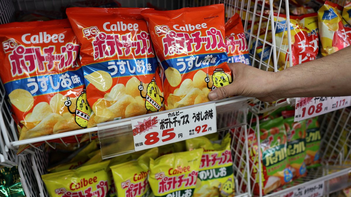 A staff member adds stock of Calbee potato chips to a shelf at a confectionery speciality store, Tokyo, Japan, May 12, 2026. (Reuters Photo)